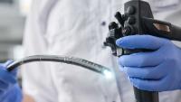 Doctor holding endoscope during gastroscopy.